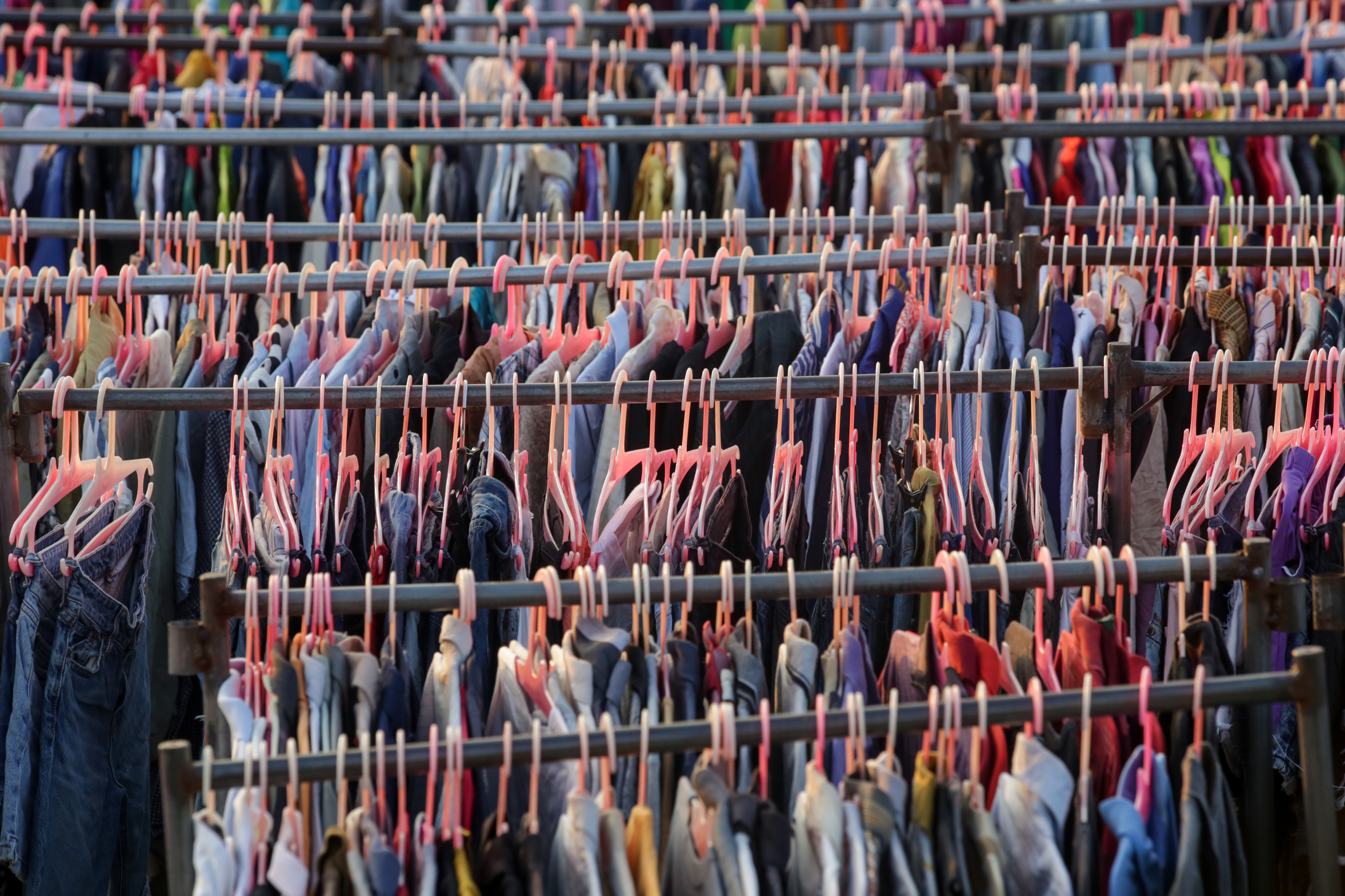 
Gran selección de diferentes prendas usadas para hombres, mujeres y niños en el estante de una tienda de segunda mano o de segunda mano. Concepto de problema de residuos en la industria de la moda.